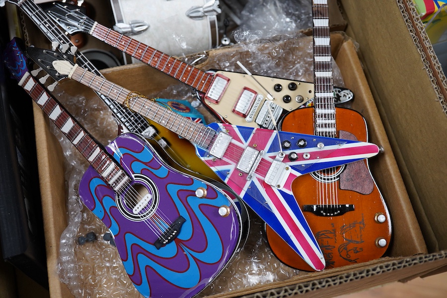 A collection of Beatles memorabilia including; models of a Beatles drum kit and eight miniature guitars and stands, each approx 25cm long, together with three boxed Corgi Beatles related models, including the Yellow Subm